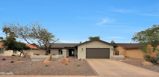 ranch-style house featuring a garage, driveway, and stucco siding