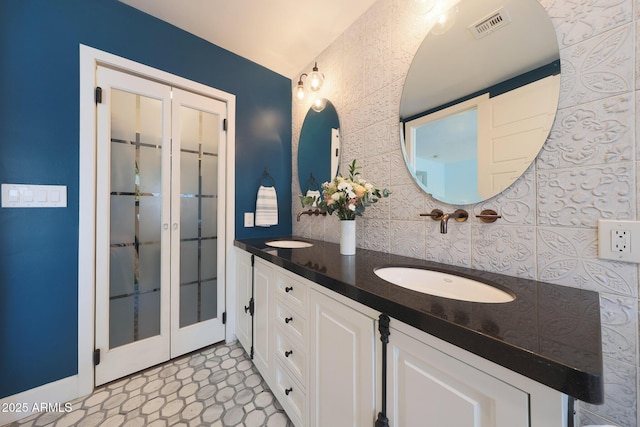 full bathroom featuring double vanity, a sink, and visible vents