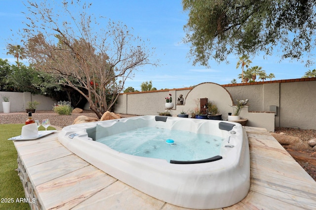 view of swimming pool featuring a fenced backyard and a hot tub