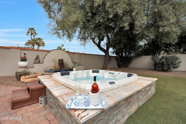 view of patio / terrace featuring a fenced backyard and an outdoor hot tub