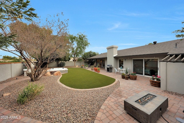 view of yard featuring a patio, an outdoor fire pit, and a fenced backyard