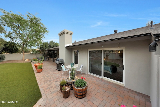 view of patio with a grill and fence