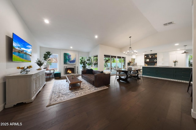 living room featuring dark wood-type flooring, recessed lighting, visible vents, and a fireplace