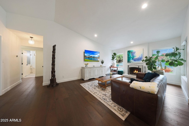 living area with lofted ceiling, recessed lighting, dark wood-type flooring, baseboards, and a brick fireplace