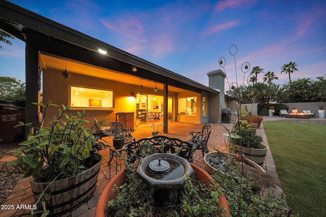 patio terrace at dusk with a yard and fence