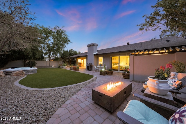 rear view of house featuring a patio, an outdoor fire pit, a fenced backyard, a yard, and stucco siding