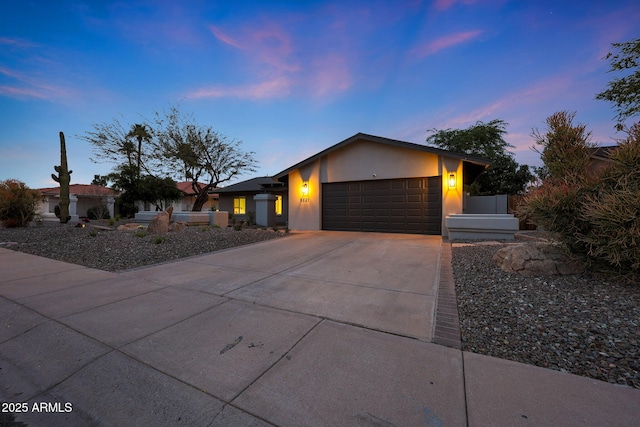 mid-century inspired home featuring an attached garage, concrete driveway, and stucco siding