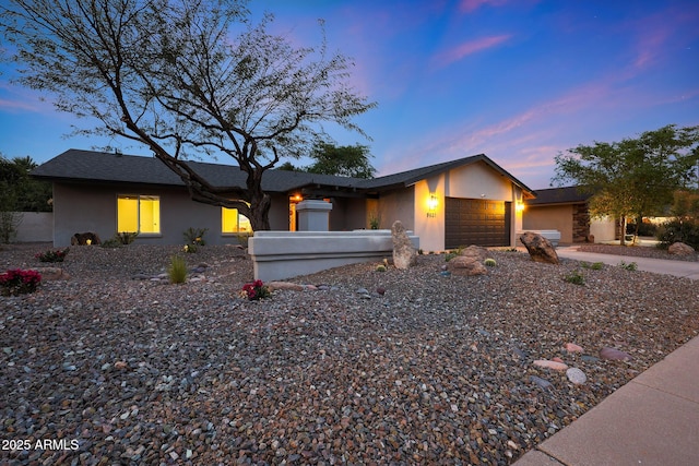 mid-century inspired home featuring driveway, an attached garage, and stucco siding