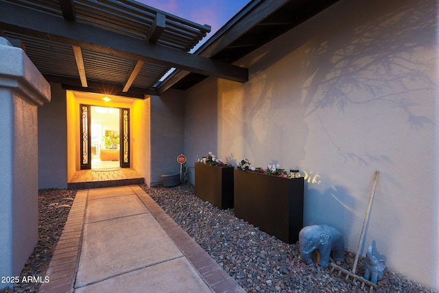 entrance to property featuring stucco siding