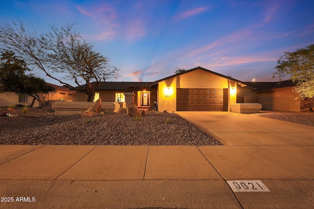 view of front facade with driveway, an attached garage, and stucco siding