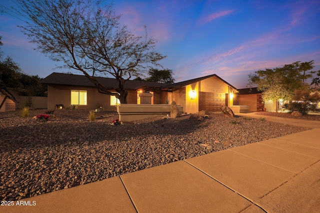 view of front of home featuring concrete driveway, an attached garage, and stucco siding