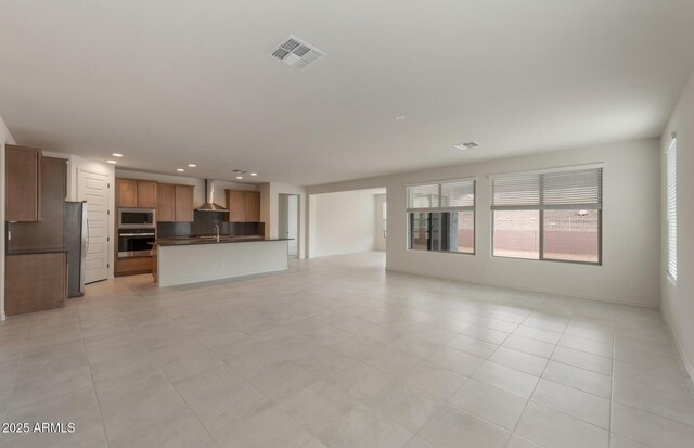 unfurnished living room featuring sink and light tile patterned floors