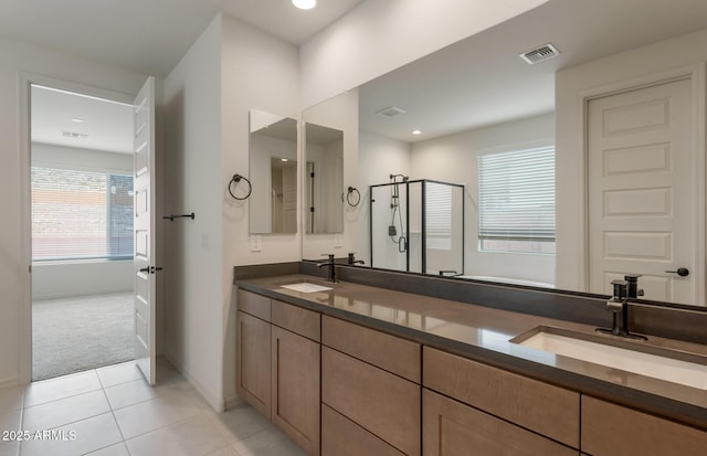 bathroom with tile patterned floors, vanity, and a shower with door