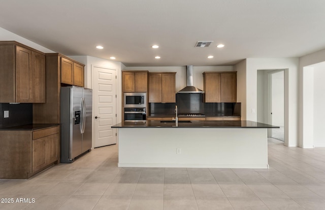 kitchen with a kitchen island with sink, wall chimney range hood, sink, and appliances with stainless steel finishes