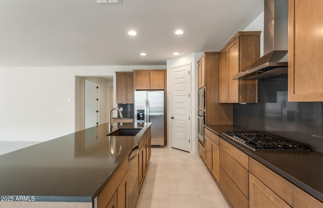 kitchen featuring wall chimney range hood, sink, backsplash, stainless steel appliances, and a spacious island