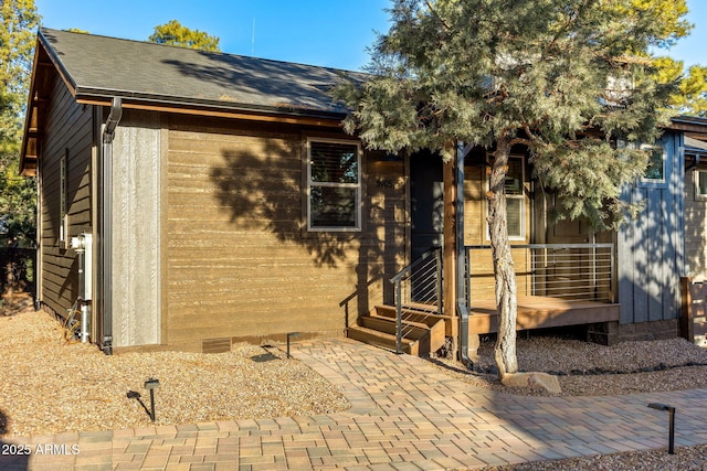 view of front of house featuring crawl space and a shingled roof