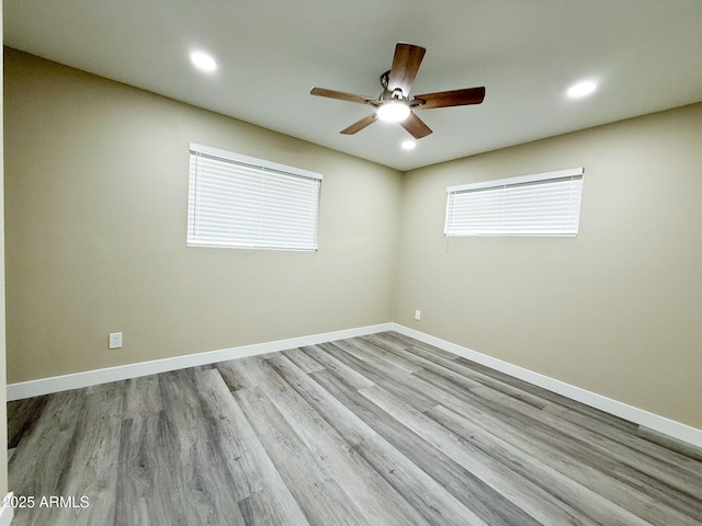 unfurnished room with wood finished floors, recessed lighting, a ceiling fan, and baseboards