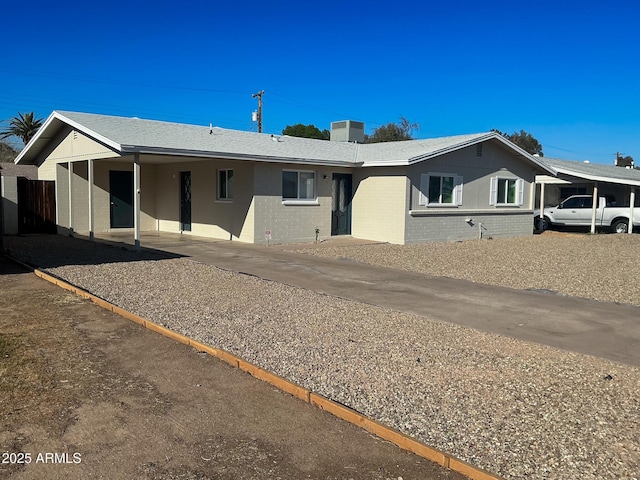 ranch-style home featuring an attached carport, central air condition unit, and brick siding