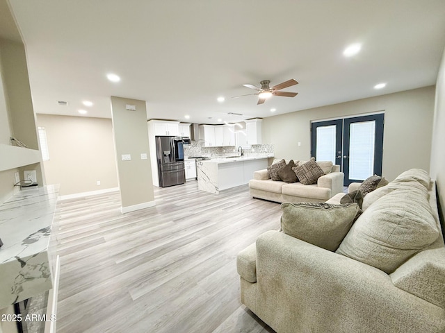 living area with light wood finished floors, recessed lighting, french doors, and a ceiling fan