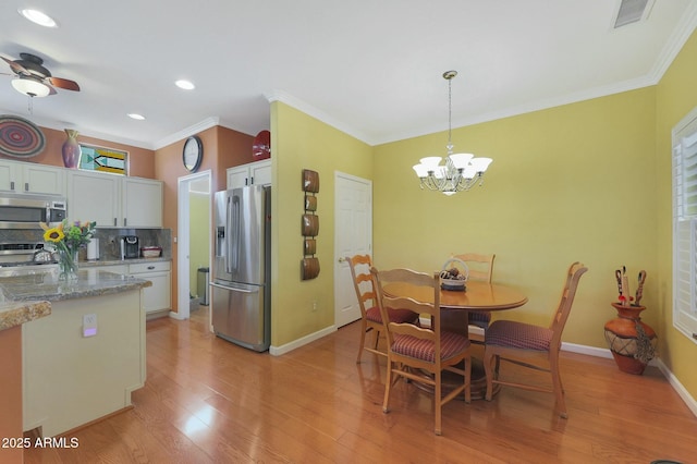 dining area with ceiling fan with notable chandelier, ornamental molding, and light hardwood / wood-style floors