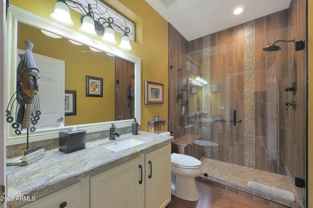 bathroom featuring vanity, toilet, hardwood / wood-style flooring, and a shower with door