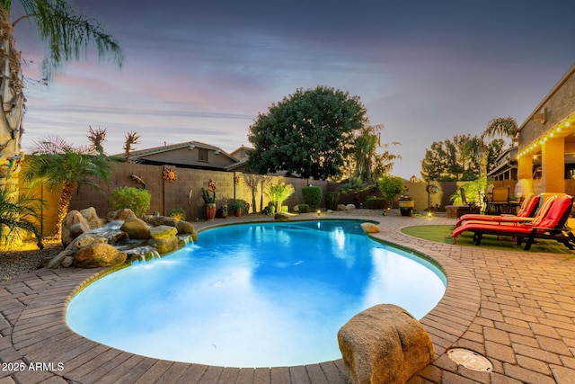 pool at dusk with a fenced backyard, a fenced in pool, and a patio