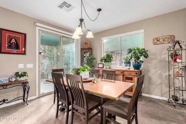 tiled dining room featuring visible vents and baseboards