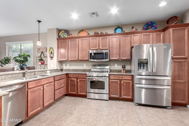 kitchen featuring stainless steel appliances, brown cabinetry, and visible vents