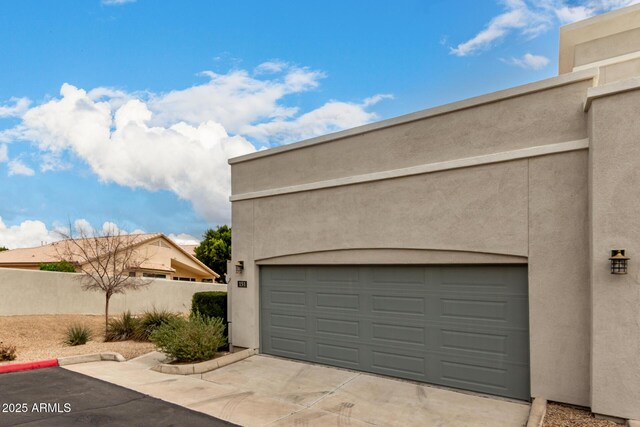 garage with driveway and fence