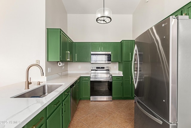 kitchen featuring sink, light tile patterned floors, green cabinets, stainless steel appliances, and light stone counters