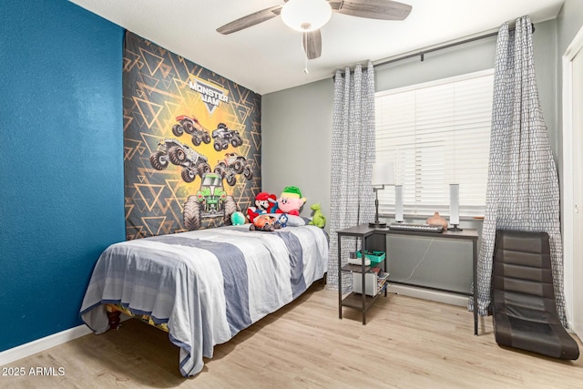 bedroom featuring a baseboard radiator, ceiling fan, and light wood-type flooring