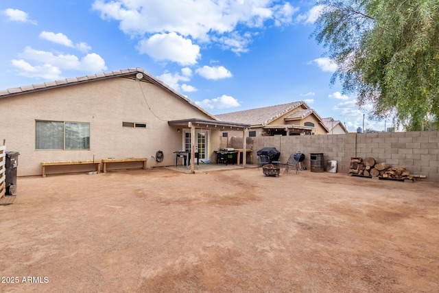 rear view of property with a patio and an outdoor fire pit