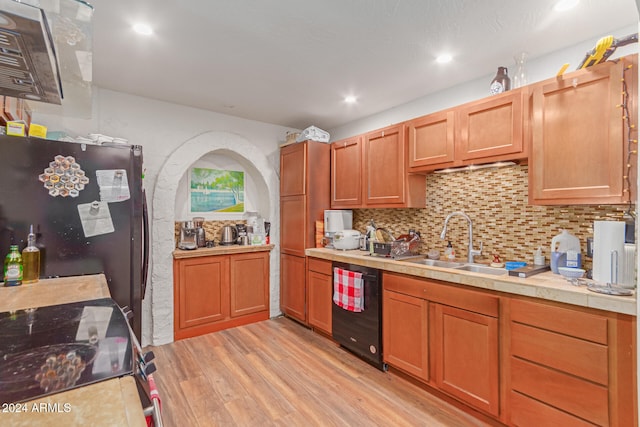 kitchen featuring black appliances, sink, tile countertops, decorative backsplash, and light hardwood / wood-style flooring