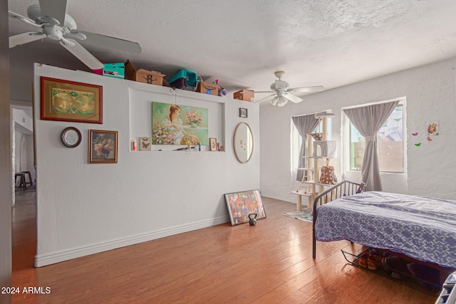 bedroom featuring hardwood / wood-style floors, a textured ceiling, and ceiling fan