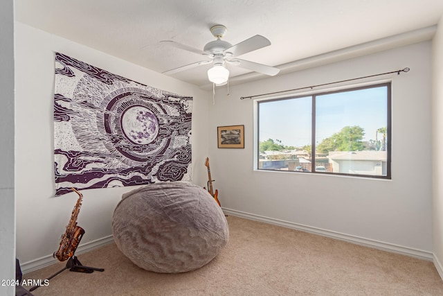 living area featuring light colored carpet and ceiling fan