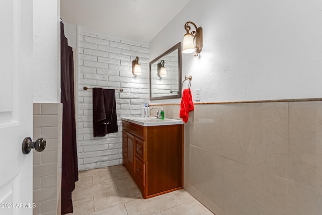 bathroom with tile walls, vanity, and tile patterned flooring