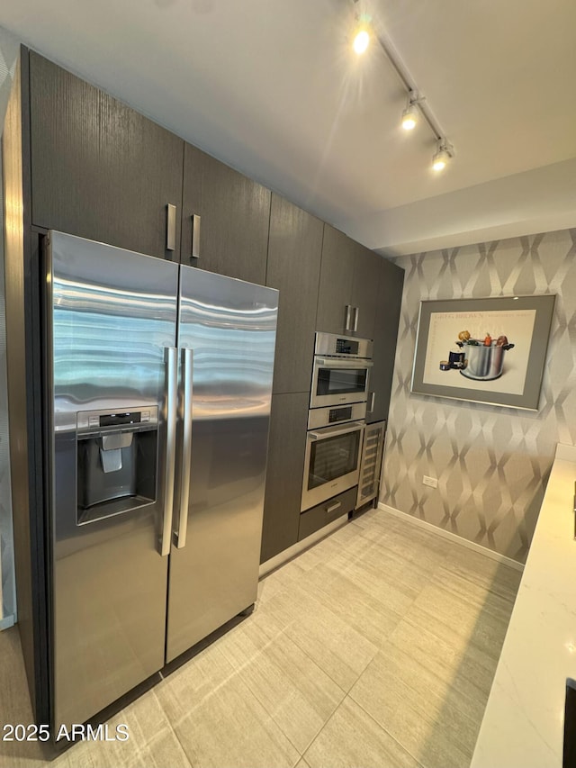 7120 E Kierland Blvd Unit 404, Scottsdale, AZ 85254 - kitchen with stainless steel appliances, rail lighting, wallpapered walls, and light countertops