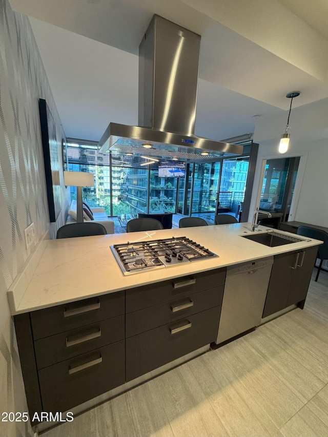 7120 E Kierland Blvd Unit 404, Scottsdale, AZ 85254 - kitchen featuring island exhaust hood, stainless steel appliances, dark cabinetry, decorative light fixtures, and light wood-type flooring