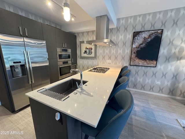 7120 E Kierland Blvd Unit 404, Scottsdale, AZ 85254 - kitchen with stainless steel appliances, island range hood, wallpapered walls, a peninsula, and light stone countertops