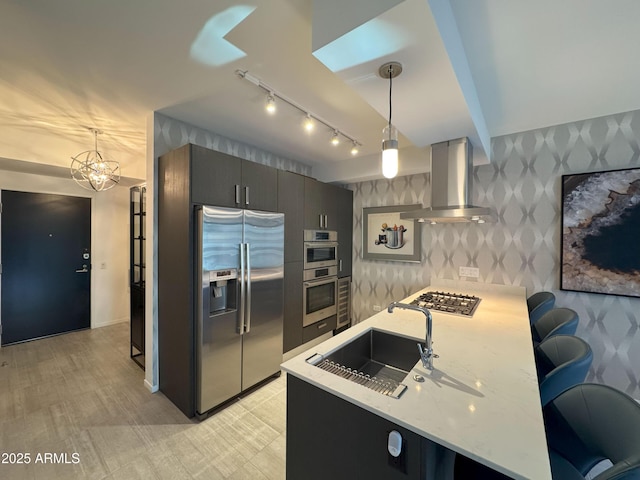 7120 E Kierland Blvd Unit 404, Scottsdale, AZ 85254 - kitchen featuring stainless steel appliances, island exhaust hood, wallpapered walls, a peninsula, and track lighting
