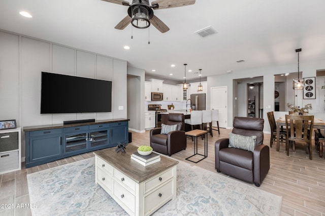 living room featuring sink and ceiling fan