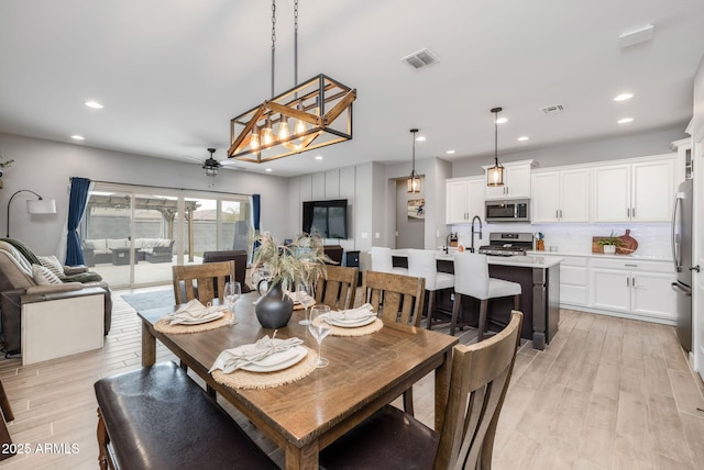 dining room with ceiling fan and light hardwood / wood-style floors