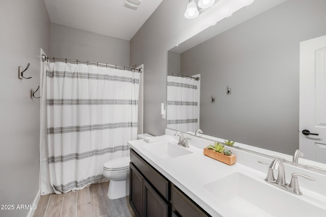 bathroom with a shower with curtain, vanity, hardwood / wood-style floors, and toilet