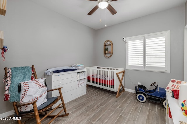 bedroom featuring a crib and ceiling fan