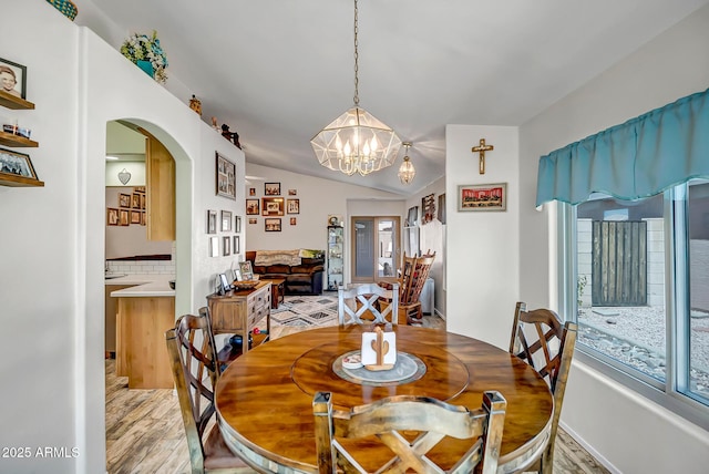 15558 N Ulrich Way, Surprise, AZ 85374 - dining room with arched walkways, light wood-style floors, a chandelier, plenty of natural light, and lofted ceiling