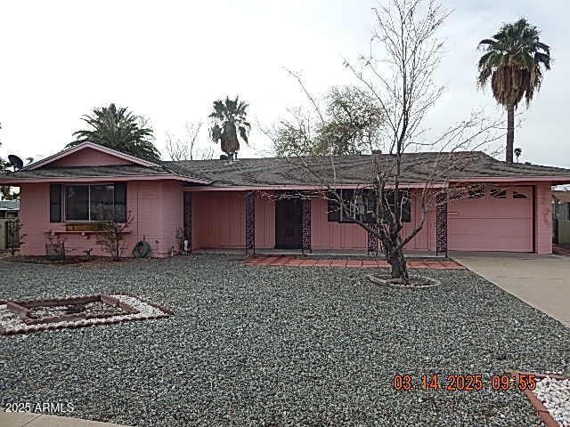 ranch-style house featuring a garage and driveway