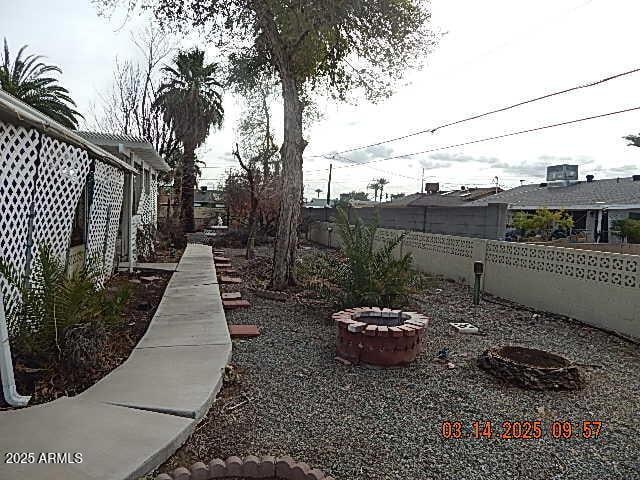 view of yard with a fenced backyard and an outdoor fire pit