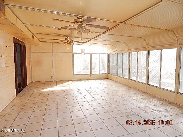 unfurnished sunroom with a ceiling fan