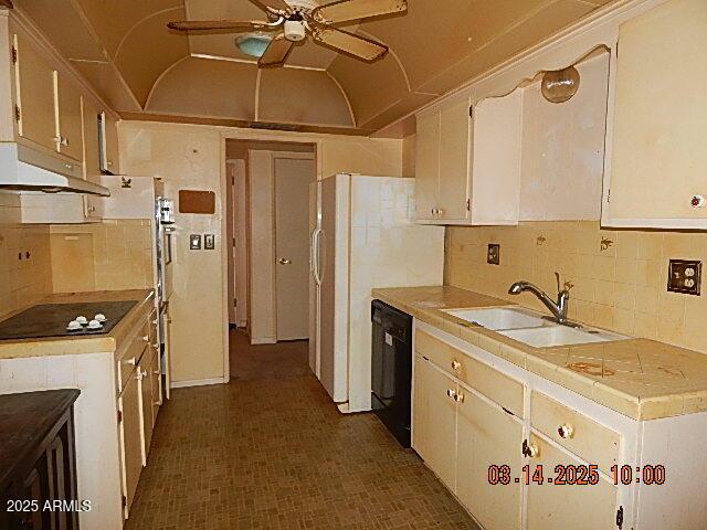 kitchen with a sink, ceiling fan, black appliances, vaulted ceiling, and light countertops