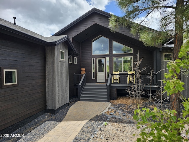 view of exterior entry featuring a wooden deck